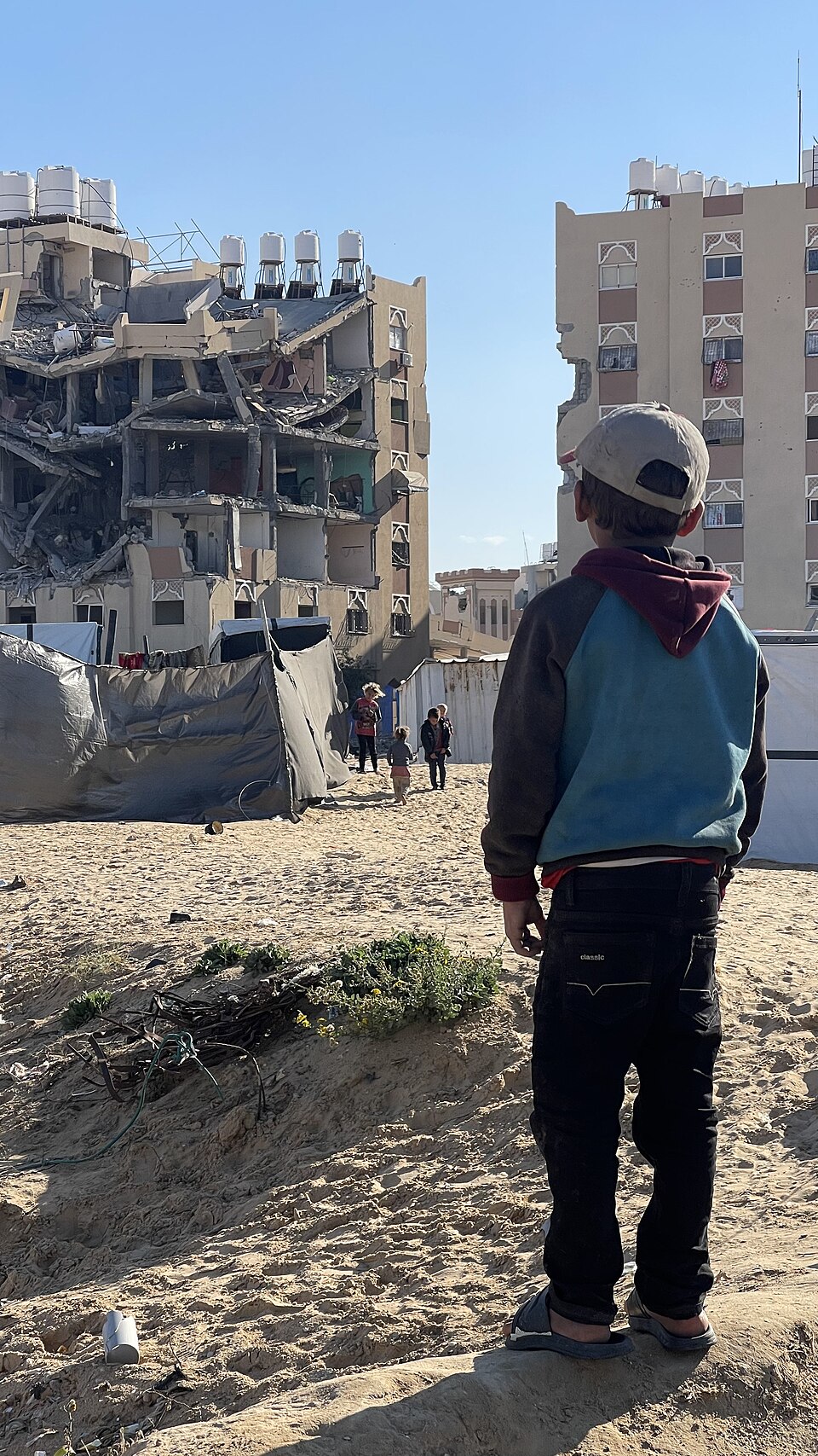 A child in front of buildings destroyed during the Gaza war.