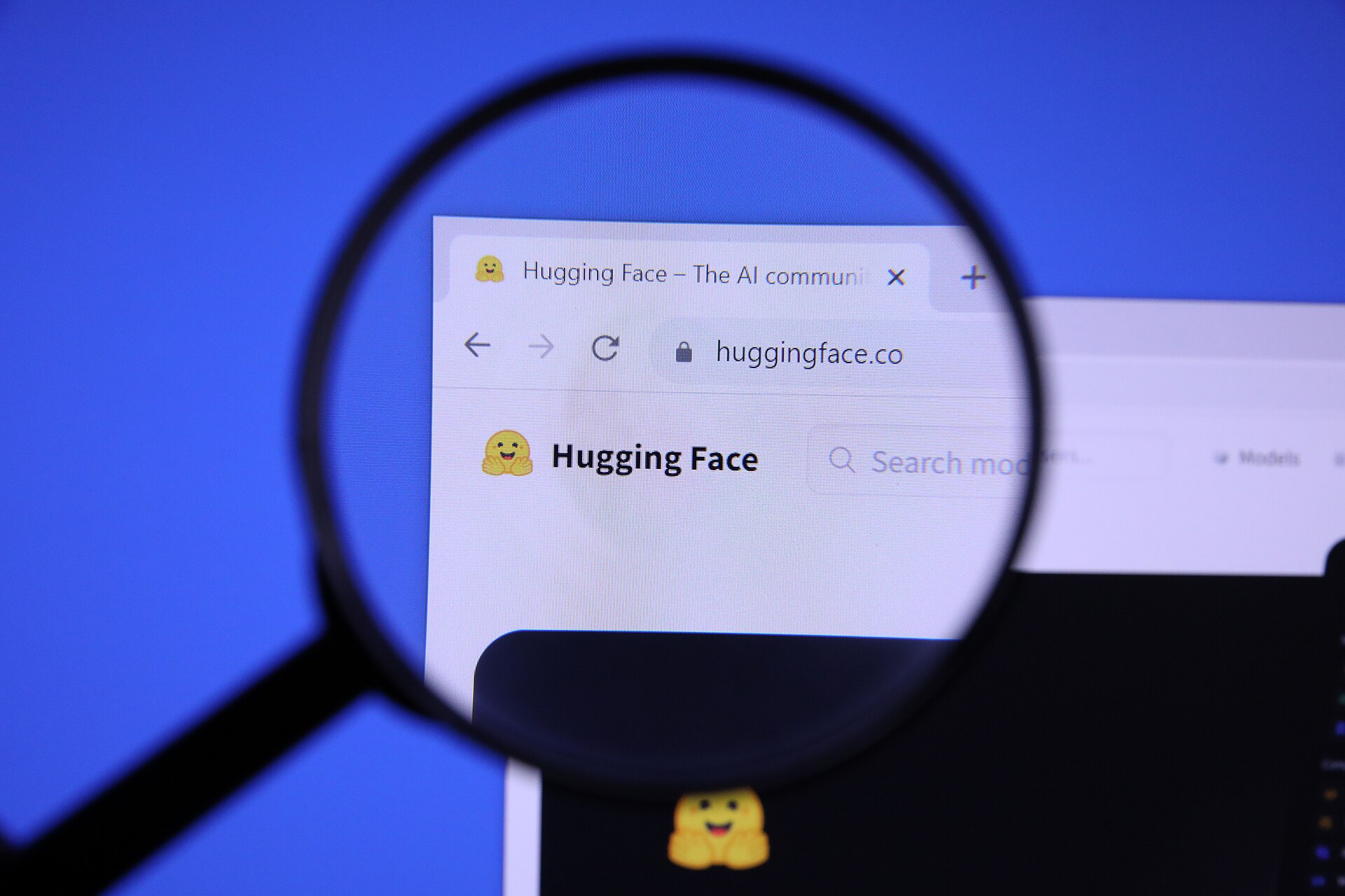 The Hugging Face website homepage viewed through a magnifying glass