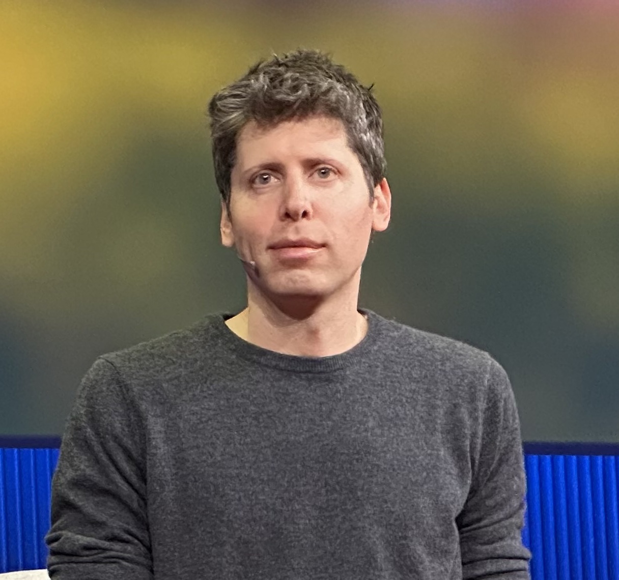Sam Altman speaking on stage at a TED conference